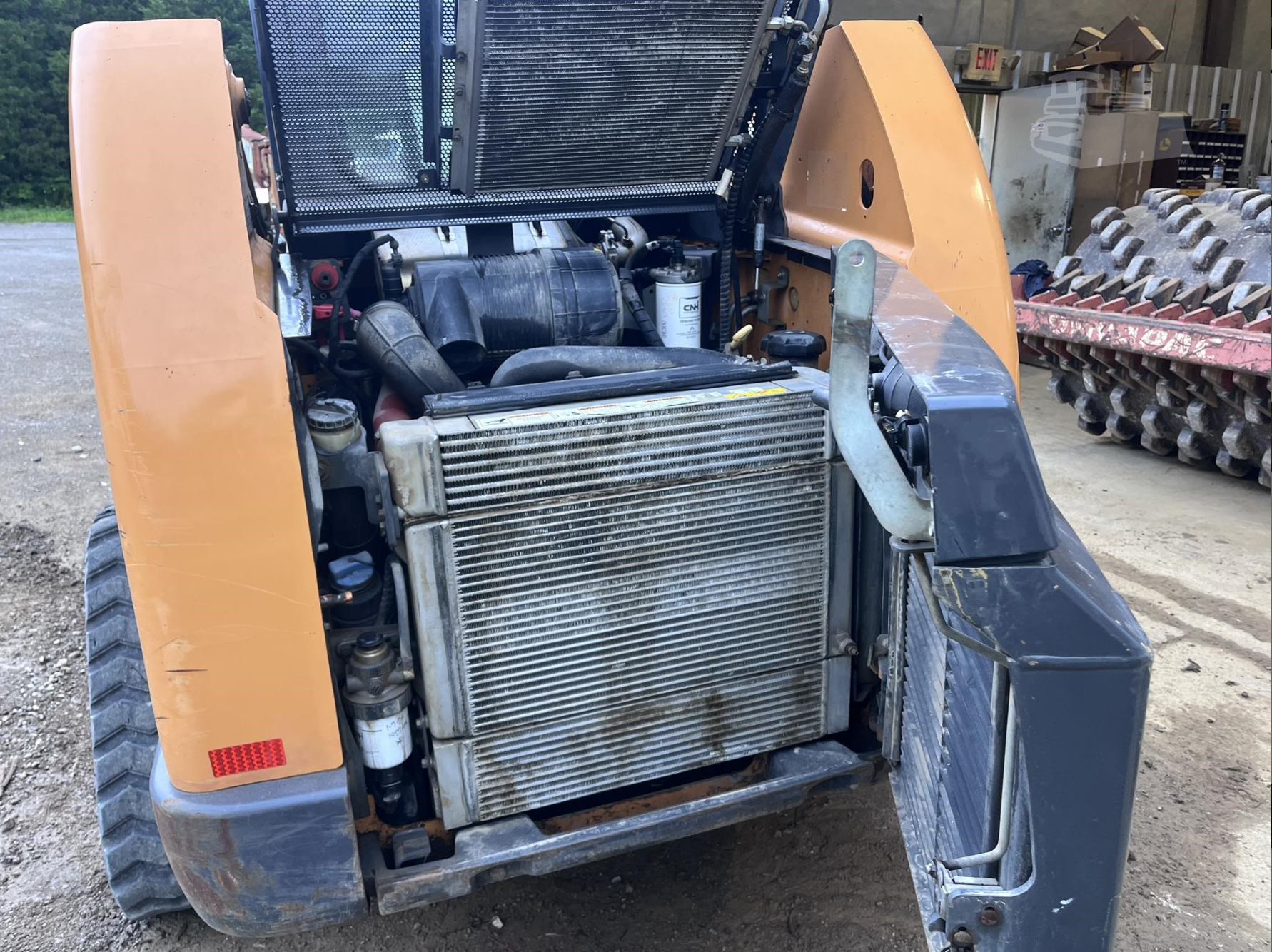 Open engine compartment of compact loader