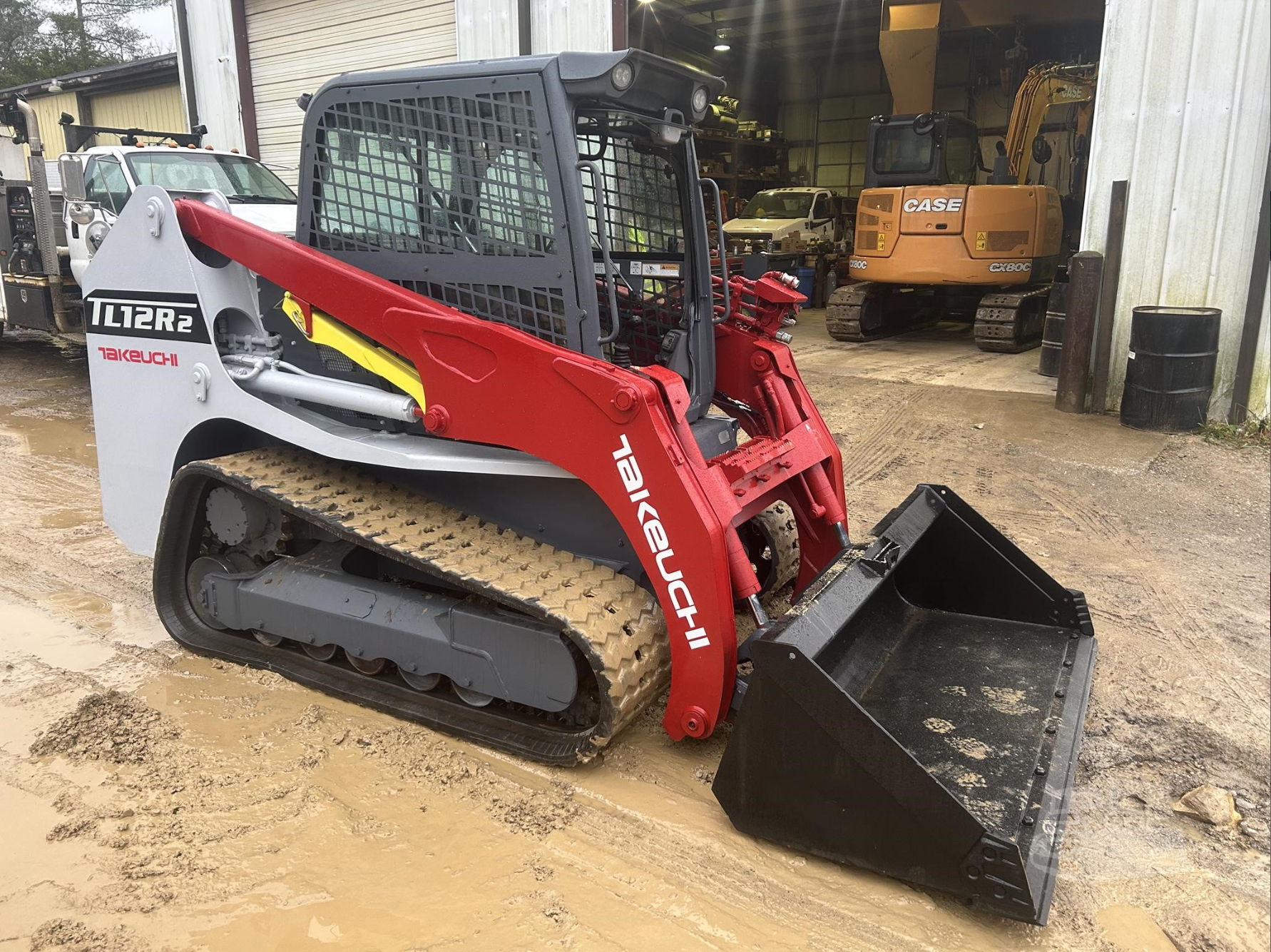 Red and white Takeuchi tracked loader with bucket